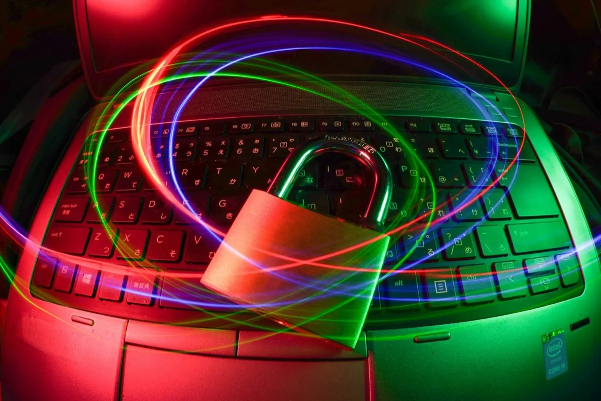 A padlock resting on a laptop keyboard, ringed by light trails